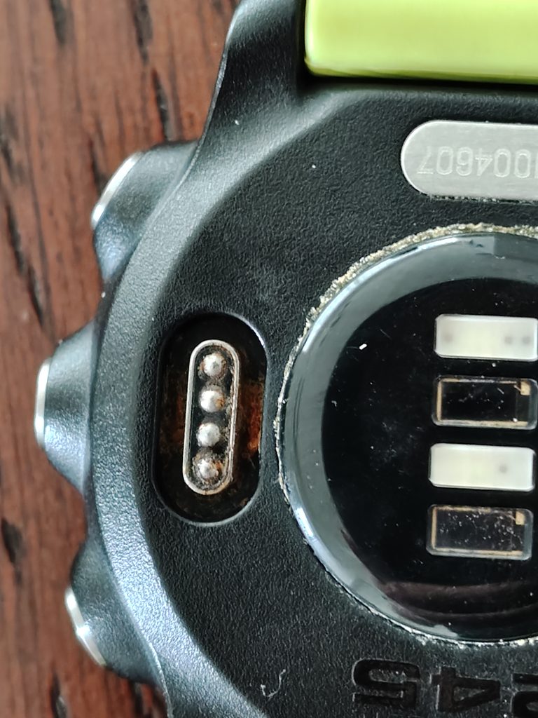Garmin 245の充電端子の外側にオレンジ色のゴミが溜まっている